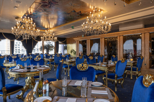 Opulent luxury restaurant interior with blue velvet chairs and crystal chandeliers