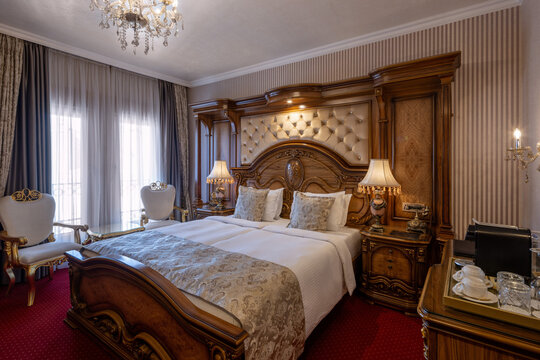 Luxury double bed in classic hotel room with golden accents
