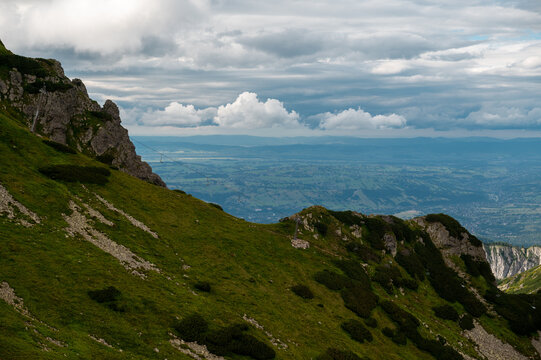 Grassy mountain ridge overlooking valley on cloudy day