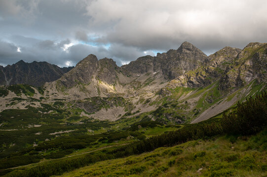 Sunbeam hits a rugged mountain under stormy skies