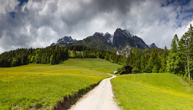 Alpine scenery with old wooden hayloft under high mountains