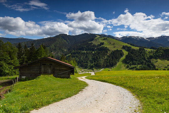Alpine scenery with old wooden hayloft under high mountains