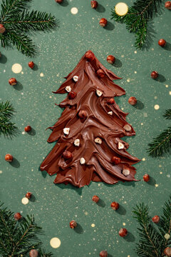 Creative chocolate spread Christmas tree with whole nuts, pine f