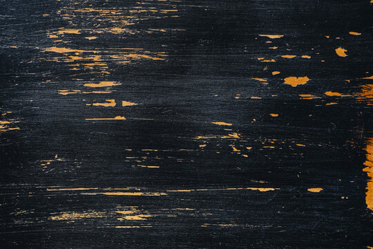 Distressed black wood texture with visible grain and peeling paint