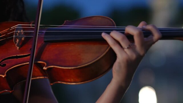 Woman playing the violin during a classical concert at night
