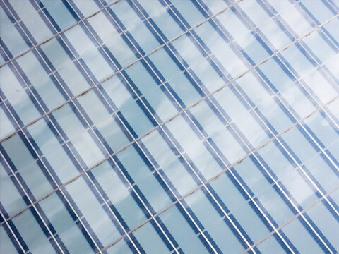 Aerial view of the glass facade of a modern building in Kaunas, featuring a geometric grid pattern reflecting the sky, Kaunas, Kaunas County, Lithuania.