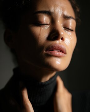 Close-up portrait of grieving woman with streaming tears down face showing powerful emotional pain perfect for funeral services bereavement support grief counseling mental health therapy concept.