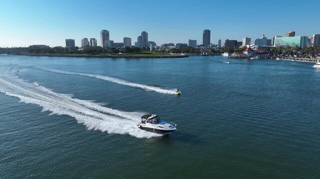Aerial view of a boat race in front of Long Beach city skyline, sunny California