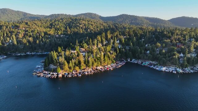 Panoramic drone shot overlooking the lakefront of Lake Arrowhead, sunset in CA