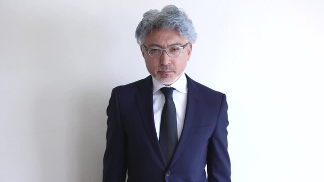 丁寧にお辞儀をするスーツ姿の中高年男性ビジネスマン