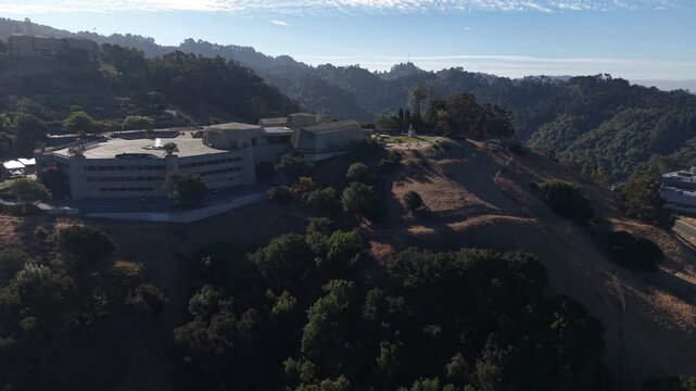 Sweeping aerial perspective of the Lawrence Hall of Science at the University of California, Berkeley, nestled in the scenic hills with morning light casting long shadows over the landscape
