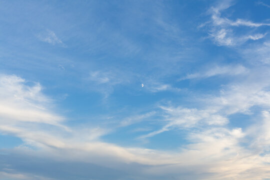 Boats floating on sea with wispy clouds