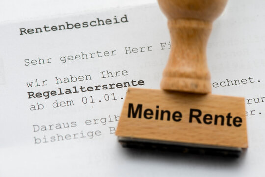 Ein Holzstempel ist beschriftet mit dem Aufdruck: Meine Rente und liegt &uuml;ber einem Rentenbescheid