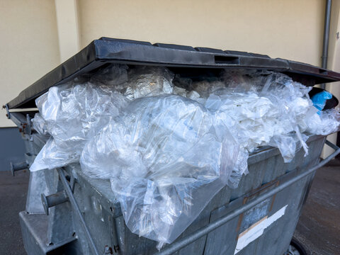 Black Trash Can Filled with Plastic Waste, Plastic Film and PVC &ndash; Plastic Recycling and Waste Management Concept