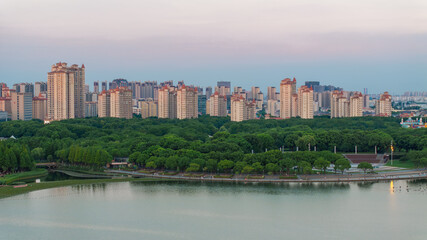 Obraz premium Urban Lakefront Skyline With Green Park at Dusk