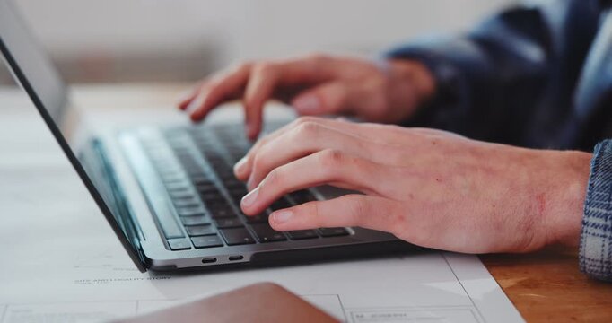 Hands, man and architect in office with laptop, research and permit application for architecture. Person, typing and blueprint in workplace with tech, client proposal and cost survey for development
