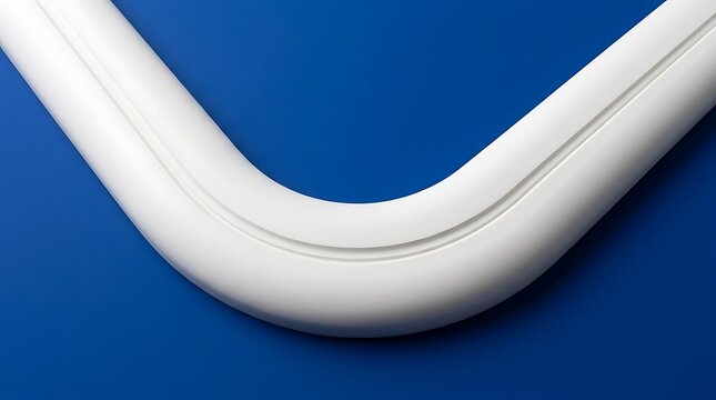 A close up view of a white plastic curved pipe section isolated on a vibrant blue background
