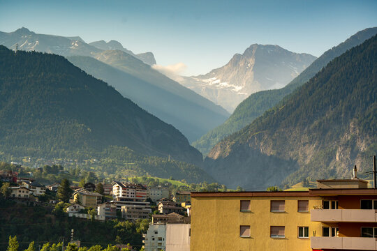 Alpine town Naters Switzerland surrounded by dramatic mountain peaks valley view clear sky sunlight landscape tourism travel