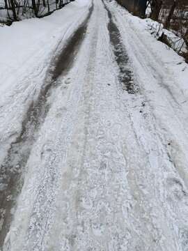 a slippery winter road in the village, covered in ice