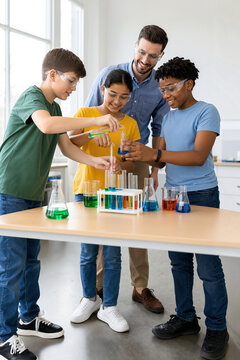 Engaging science experiment with diverse students mixing colorful liquids in laboratory beakers.