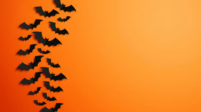 Black silhouetted bats flying in formation against orange backdrop