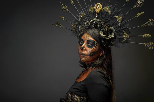 Woman Dressed as Catrina With Gold Skull Makeup and Black Floral Headdress