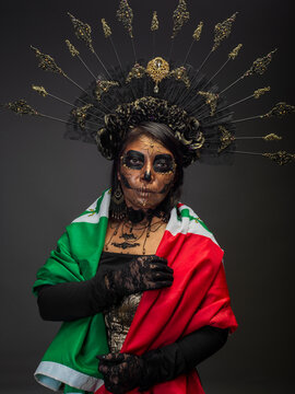Woman Dressed as Catrina With Sugar Skull Makeup Draped in Mexican Flag