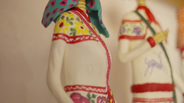 Close macro details of painted Catrina figurines highlighting handmade white and floral patterns, traditional artisan craftsmanship