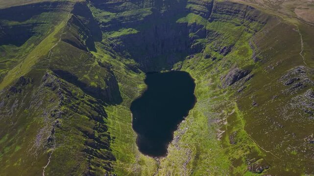 Scenic aerial of Coumshingaun glacial lake surrounded by rugged Irish mountains
