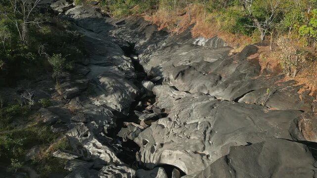 Sculpted quartzite bedrock of the Sao Miguel River at Vale da Lua, Chapada dos Veadeiros National Park, Alto Paraiso de Goias, Goias, Brazil, reveals remarkable fluvial erosion, drone forward flyover