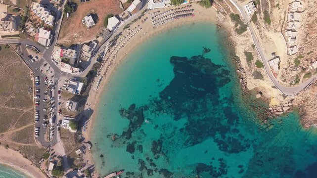 Overhead drone footage capturing the transparent waters and golden shoreline of Lefkos Beach, highlighting the natural beauty of Karpathos Island, Greece.