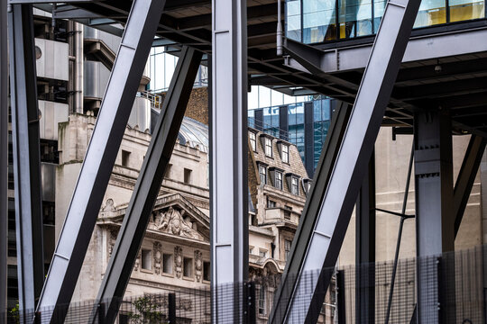 Between old stone and open depth, steel beams establish framing across a historic facade, where modern architecture builds urban contrast through the layered structure