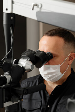 Dentistry, experienced dentist using a professional dental microscope for precise oral examination in a modern clinic. Advanced technology supports accurate diagnosis and patient care
