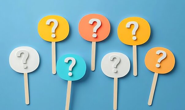 Various colorful question marks on sticks scattered on blue background, concept of inquiry.