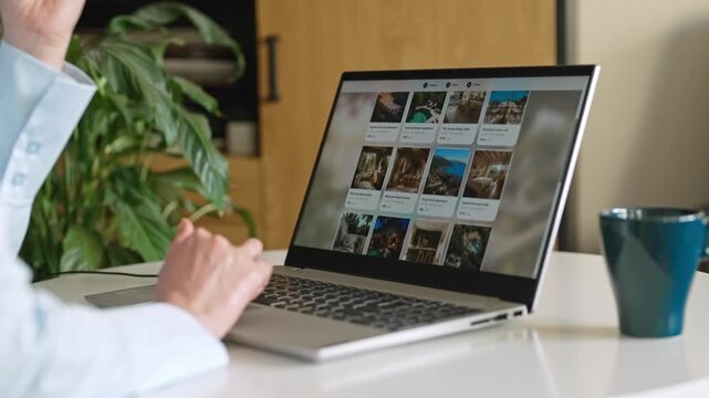 Person booking accommodation online using laptop at home desk.