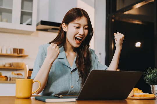 Happiness Entrepreneur beautiful business asian young woman wear casual use mobile phone for shopping online enjoy with social media and laptop at home.Small Business Startup.online banking