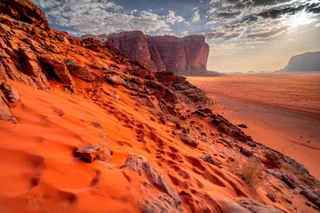 Fotobehang Rood Sunset with mountains in background in Wadi Rum desert with sand dunes. The most beautiful deserts in the world, Jordan, Middle East.  © Tomasz
