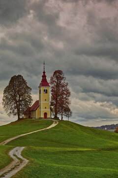 Undulating dirt trail going uphill to the Baroque, XVII c.Saint Thomas church (Cerkev svetega Tomaza) in Gorenji Vrsnik village. Idrija-Slovenia-193