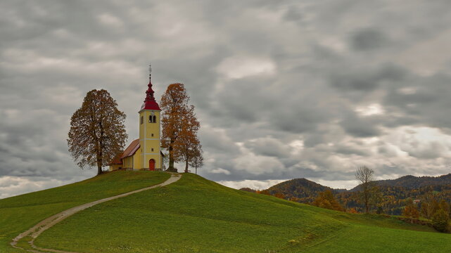 Undulating dirt trail going uphill to the Baroque, XVII c.Saint Thomas church (Cerkev svetega Tomaza) in Gorenji Vrsnik village. Idrija-Slovenia-195