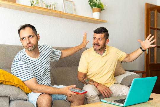 Gay couple having argument at home ignoring each other