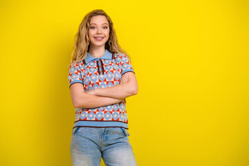 Fototapeta premium Smiling teen girl with braces in casual patterned shirt standing confidently against a bright yellow background