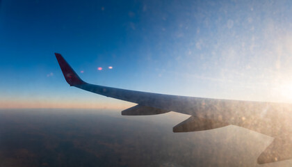 Fototapeta premium View on sunset and airplane wing from the inside