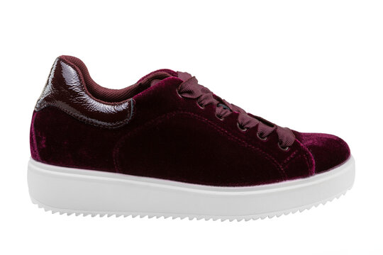 Women burgundy velvet platform sneakers isolated on white background. Casual wine red velour lace-up trainers with patent leather accent, side view.