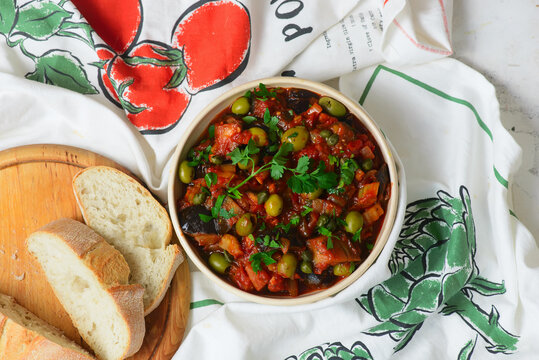 Traditional Sicilian caponata, a vegetable appetizer made with eggplant, olives, and capers in ceramic bowl