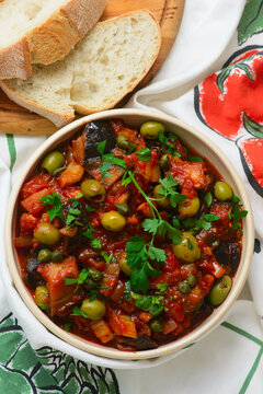 Traditional Sicilian caponata, a vegetable appetizer made with eggplant, olives, and capers in ceramic bowl