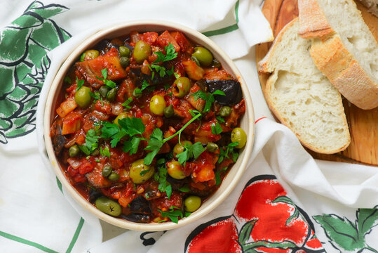 Traditional Sicilian caponata, a vegetable appetizer made with eggplant, olives, and capers in ceramic bowl