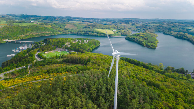 Aerial view of wind turbine above Biggesee reservoir landscape in Sauerland Germany