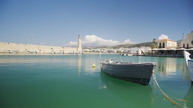 Boat in Chania Venetian harbor and historic lighthouse, Crete