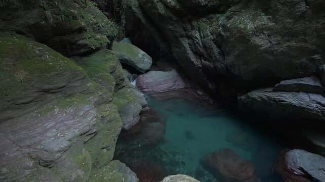 Clear blue water flows into small rocky natural pool in Shikoku, Japan