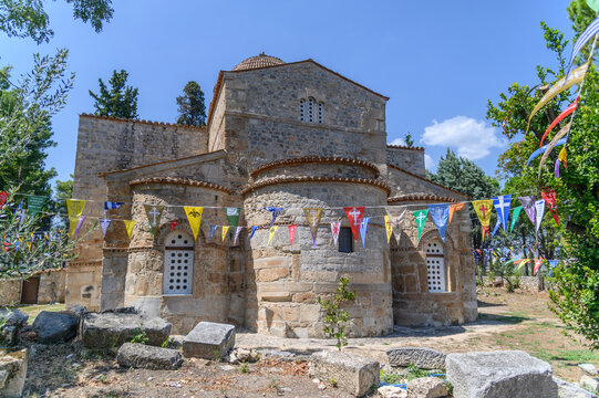Carved apses and tiled dome of the Byzantine church of Panagia Skripou strung with festival pennants, Orchomenos, Greece